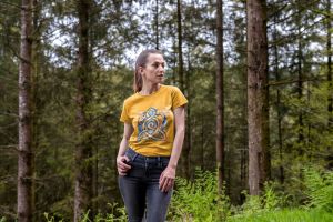 Woman wearing a Gaia's Threads T-shirt featuring a captivating illustration of the Earth adorned with the Motherhood Knot symbol.