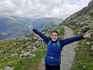 erson stretching arms with joy during a hike in Davos mountains.