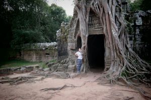View of Angkor Wat temple complex in Cambodia, featuring its iconic spires, intricate carvings, and surrounding moat, highlighting its significance as a sacred site and symbol of Khmer heritage.