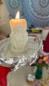 Candle with a women's figure in a ritual setting to place an intention.
