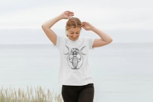 Woman wearing a Gaia's Threads T-shirt with an illustration of the Earth Goddess holding the Triple Goddess symbol